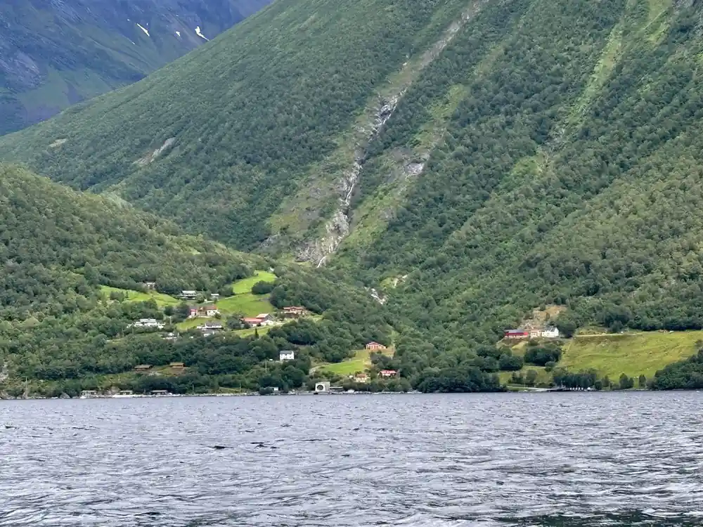 Glacier and waterfall visible in steep green valley