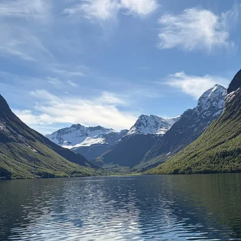 Snowy peaks above the calm water of the Hjørundfjord