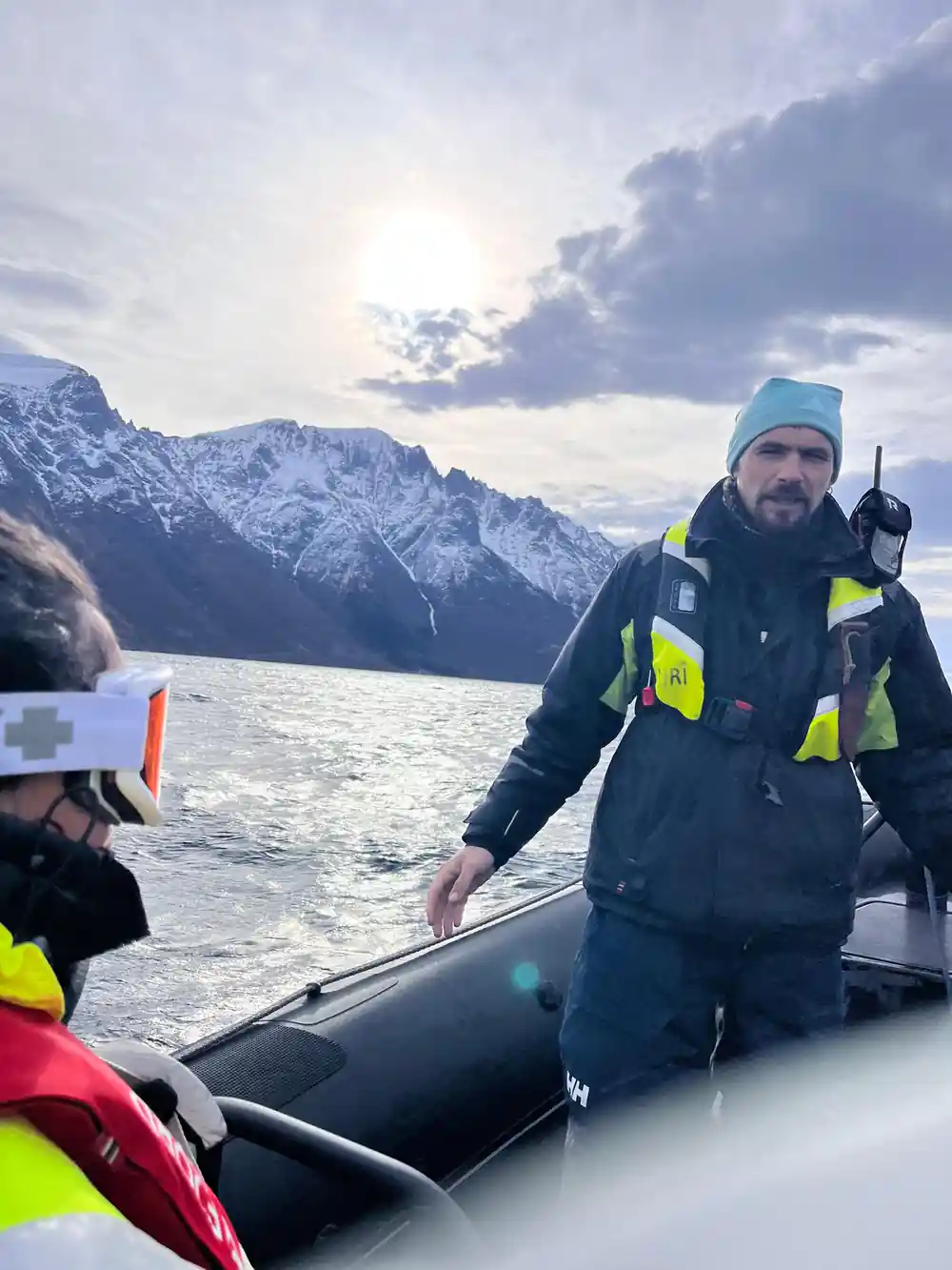 Man in high-visibility gear on speedboat