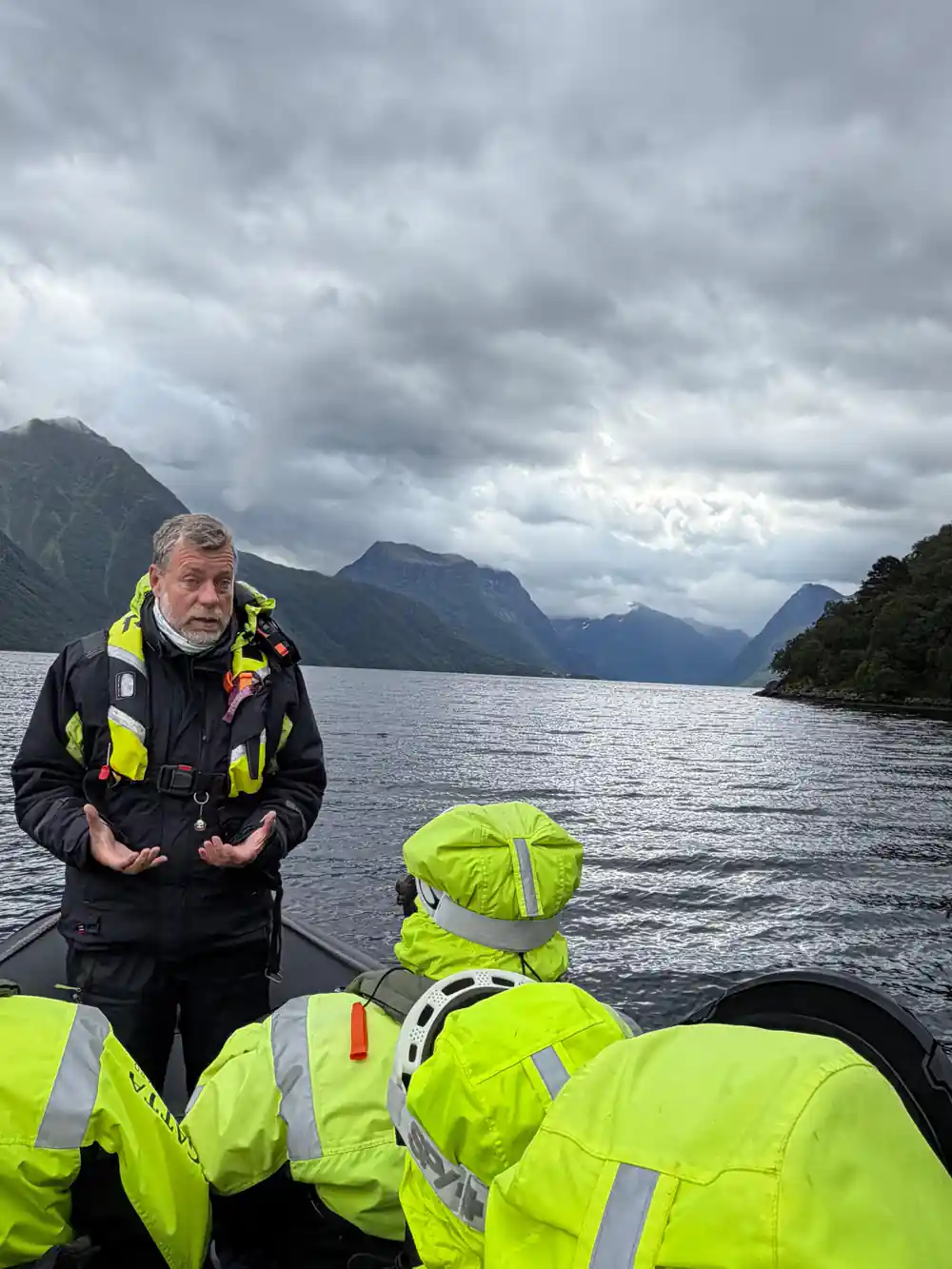 Man instructing group in safety gear on boat