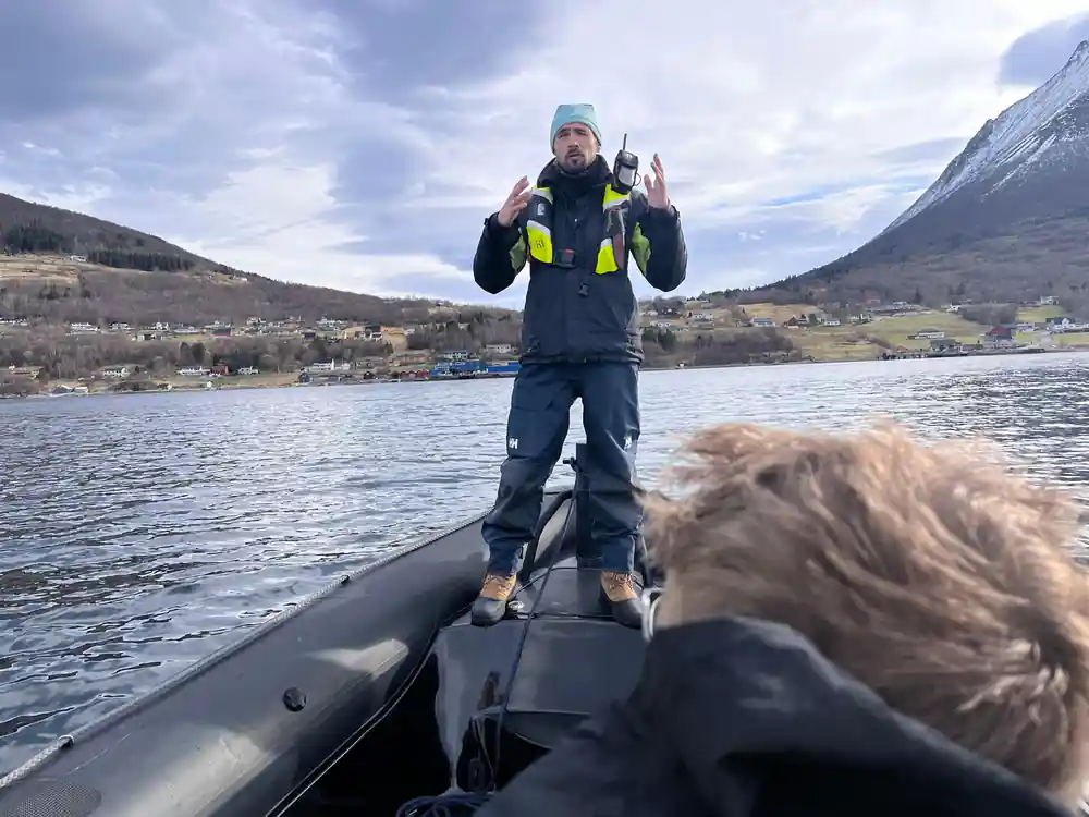 Person standing on speedboat with thumbs up
