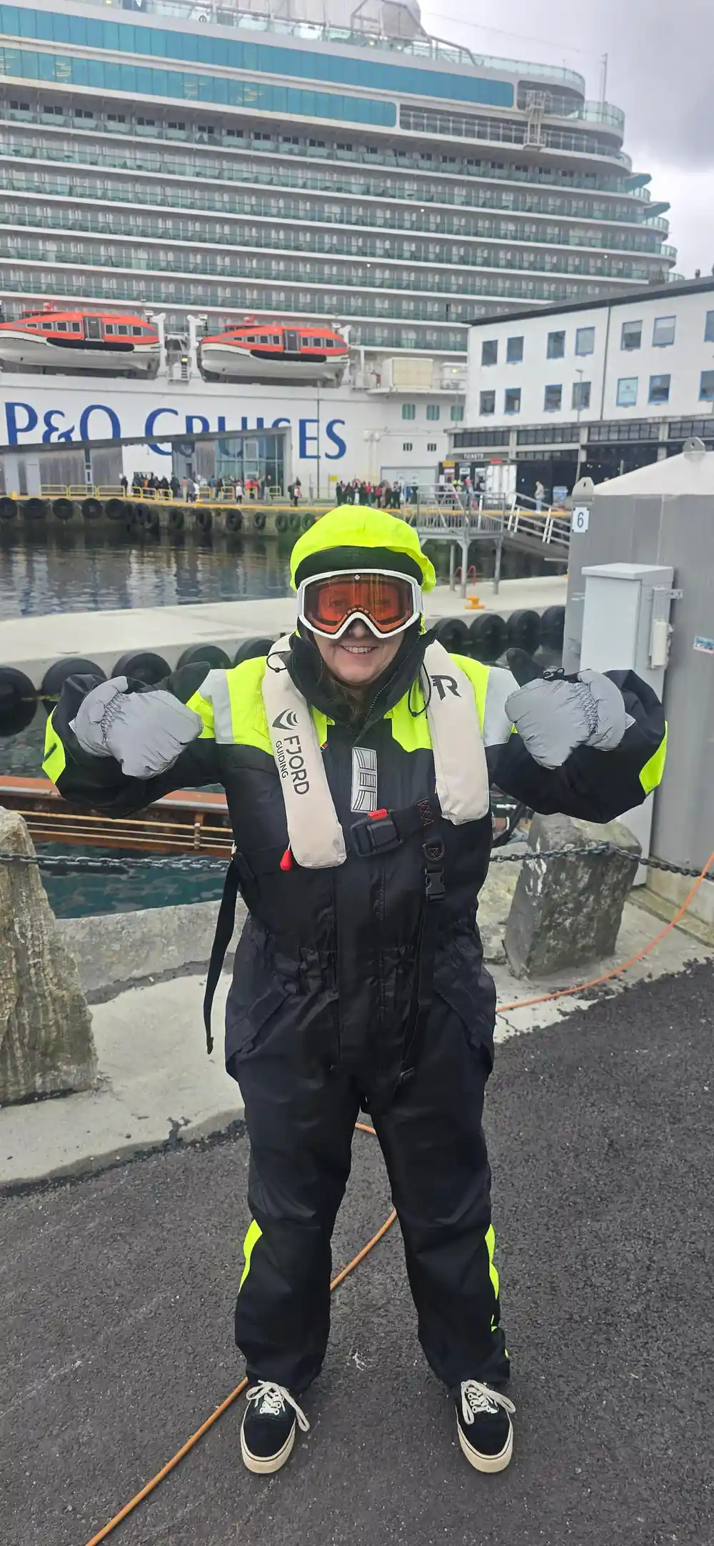 Person in yellow safety gear at cruise ship dock