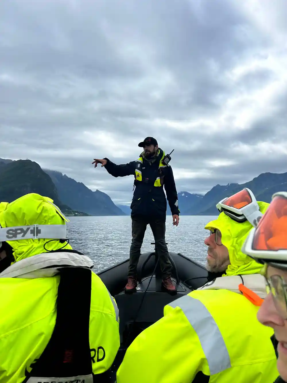 Scuba diver standing on inflatable boat with mountains