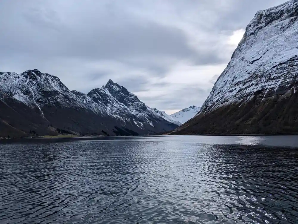 Snow-capped mountains reflected in still lake water