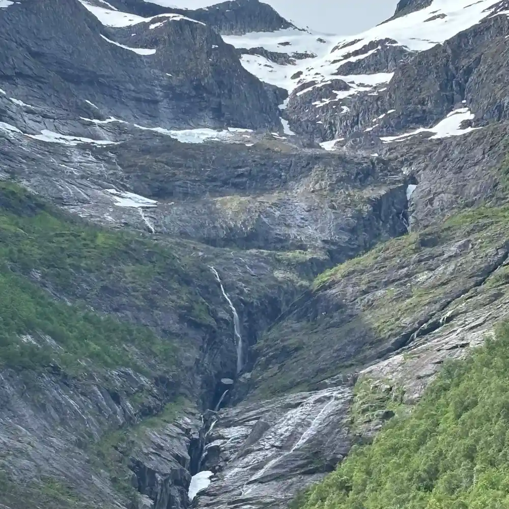 Snow-capped peaks with glacier and waterfall in valley