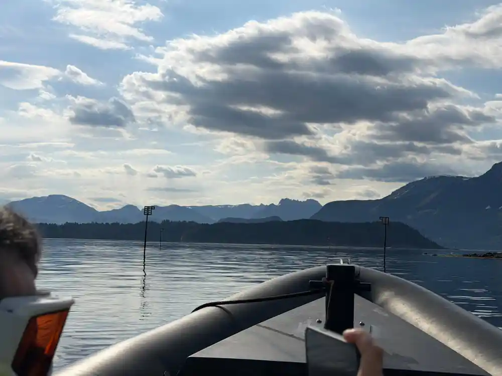 Speedboat bow view across mountain lake with clouds