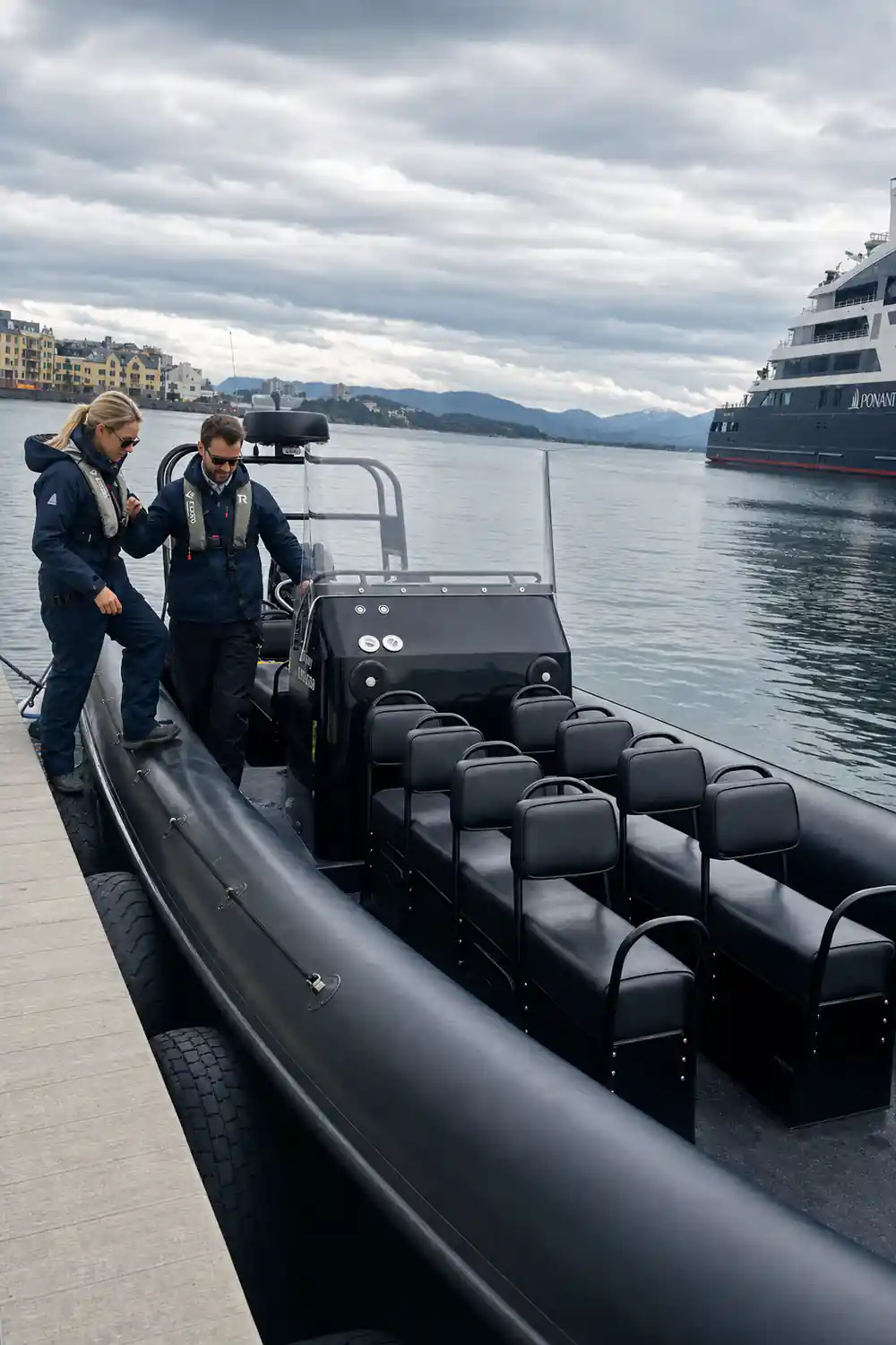 Two people in inflatable boat on calm fjord water