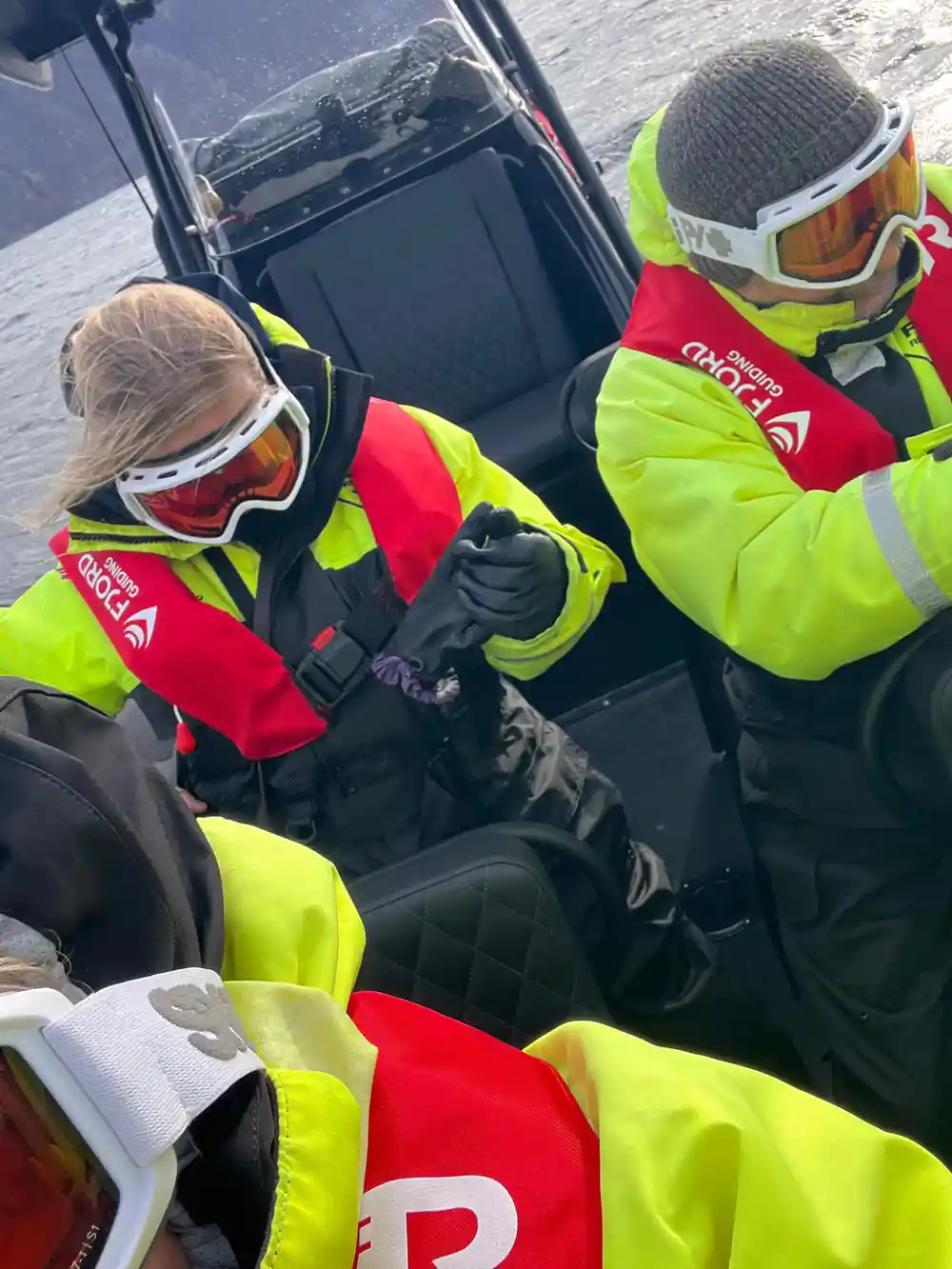 Two people in life jackets sitting in speedboat