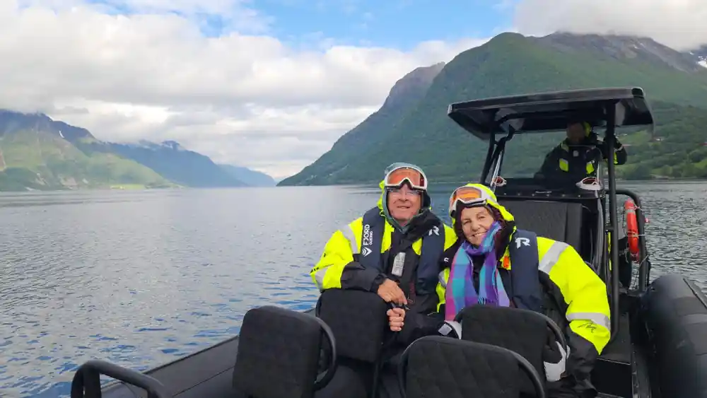 Two people in life jackets on speedboat